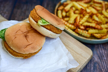   Home made  chicken Burger and   deep fried french fries on wooden   cutingboard 