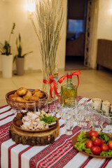Traditional Ukrainian cuisine with lard, bread, vegetables, and meat on embroidered tablecloth