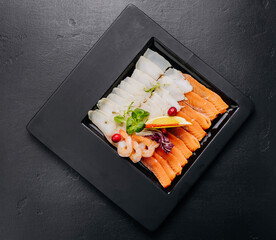 Gourmet seafood platter with fresh salmon, shrimp, and white fish fillet served with herbs and lemon