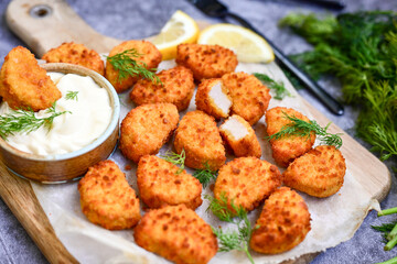 Crispy  deep fried   chicken  popcorn  nuggets and french fries . Breaded  with Cornflakes chicken  Breast fillets  with chilly peppers and fresh   basil on wooden rustic background