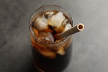 Tasty refreshing drink with straw in glass on grey table, closeup