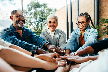 Multiethnic team showcasing teamwork with hands together in a positive business setting