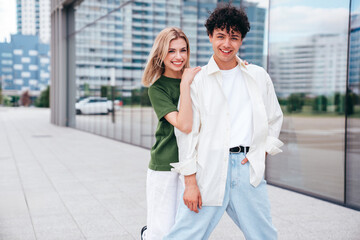 Smiling beautiful woman and her handsome boyfriend. Couple in casual summer clothes. Happy cheerful family. Female and man having fun. They posing in the street in sunny day. Having tender moments