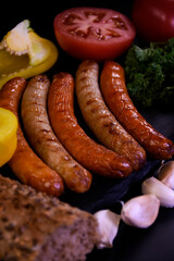Grilled sausages with fresh vegetables and bread.  Picnic food.
