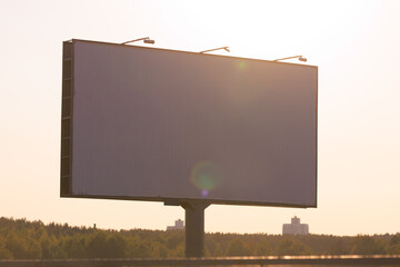 Advertising billboard along the road in the city on a sunny day. Background for design.