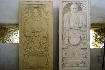 Two medieval tombstones with reliefs depicting the deceased, in the Mausoleum Tower of the fortified church of Biertan (Sibiu County, Transylvania). Ancient gravestones of the nobility in Romania.