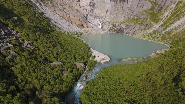 Scenic Briksdalsbreen Glacier in Norway, Scandinavia with thick ice and lake. Epic mountain nature aerial.