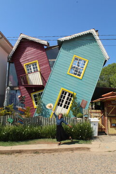 turista em frente a casa torta, em bichinho, minas gerais 