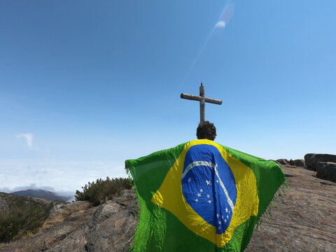 homem segurando bandeira do brasil no pico da bandeira, no parque nacional do capara&oacute;, divisa entre minas gerais e esp&iacute;rito santo 