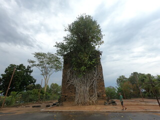 Obraz premium Ruínas da Igreja do Senhor Bom Jesus de Matozinhos, no Distrito de Barra do Guaicuí, em Várzea da Palma, Minas Gerais. Construção está abraçada por raízes de árvore 
