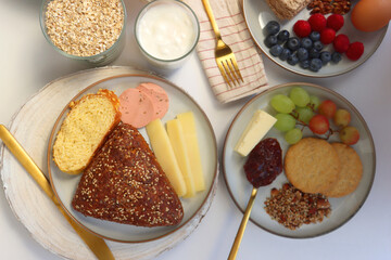 Assortment of various breakfast foods and drinks on the white table. Flat lay.