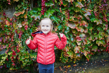 Adorable preschooler girl enjoying autumn day outdoors. Happy child gathering autumn leaves in Paris, France. Outdoor fall activities for kids.