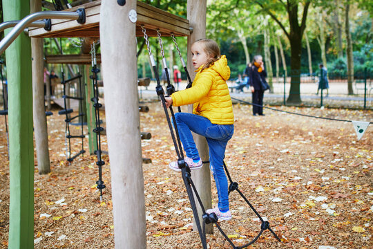 Adorable preschooler girl on playground on a sunny autumn day. Preschooler child playing outdoors. Outdoor activities for kids