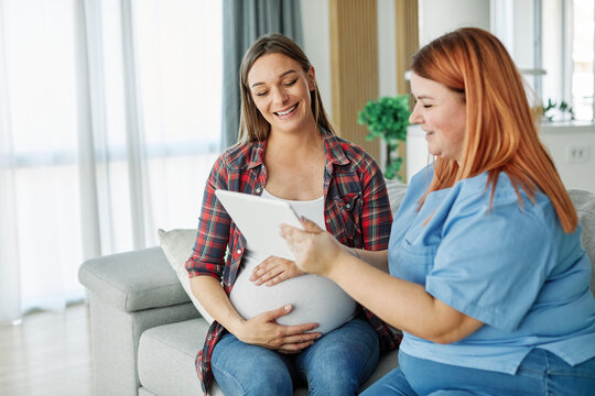 woman pregnant mother pregnancy belly patient nurse visit control exam test maternity computer visit technology hospital talking tablet support explaining