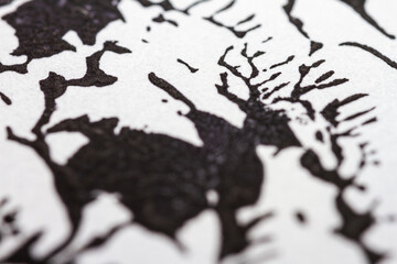 Extreme close up of black acrylic paint texture on paper. Selective focus.
