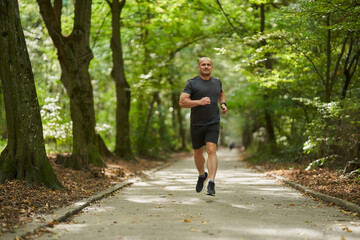 Obraz premium Athletic man running in park