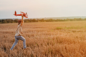 Handsome child boy running,wooden airplane. Kid dreaming to be pilot. Copy space