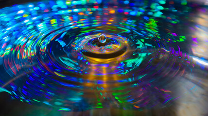 A stunning indoor shot captures a water droplet, its surface reflecting intricate patterns and...