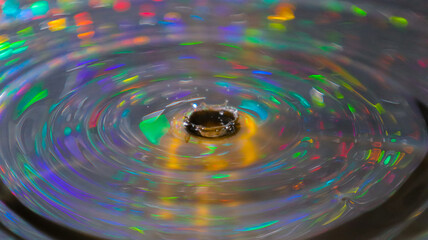 A stunning indoor shot captures a water droplet, its surface reflecting intricate patterns and...