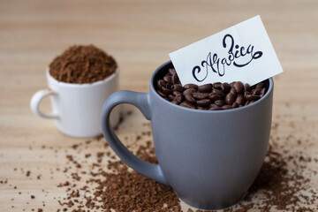 Coffee beans arabica In a gray ceramic mug on wooden floor with the message on the brown card.