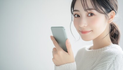 Naklejka premium A closeup of a beautiful Japanese woman holding her phone
