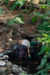 Woman washing clothes in a rural stream in El Salvador
