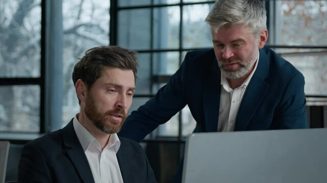 Caucasian men businessmen business partners looking computer screen in office coworkers argue shout because failed online project angry aggressive stressed man boss arguing with male employee conflict