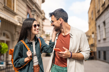 Beautiful young alternative hipster tourists couple in love walking outdoors at the city street,...