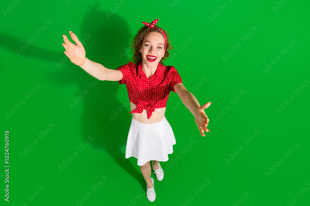 Poster Full size photo of pretty young girl tow view stretch hands wear trendy red retro outfit isolated on green color background