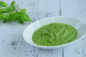 bowl of basil pesto, selective focus. White background