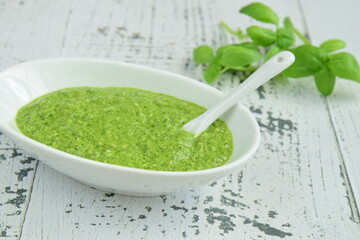 bowl of basil pesto, selective focus. White background