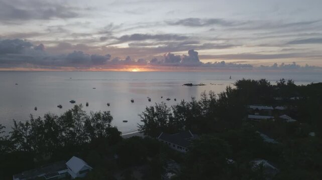 Aerial footage of tropical sunset on an siland withj ocean and boats. Mauritius