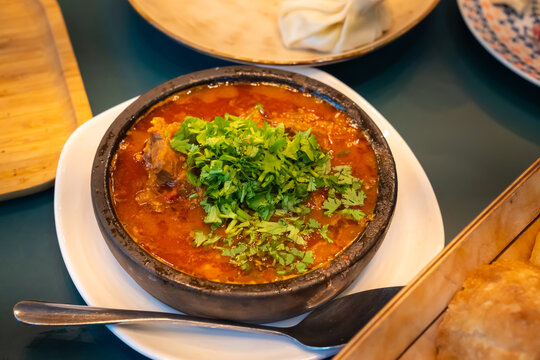 Fragrant Georgian dish ostri, stewed over low heat with tender beef, herbs and spices, is served in a traditional ketsi clay pot, demonstrating the rich taste of Georgian cuisine