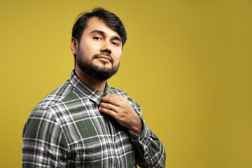 Obraz premium serious man fixing the collar of his button-down shirt