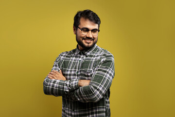 man in glasses with arms crossed, smiling and looking down