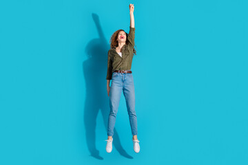 Full size photo of nice young lady jump hold empty space wear shirt isolated on teal color...