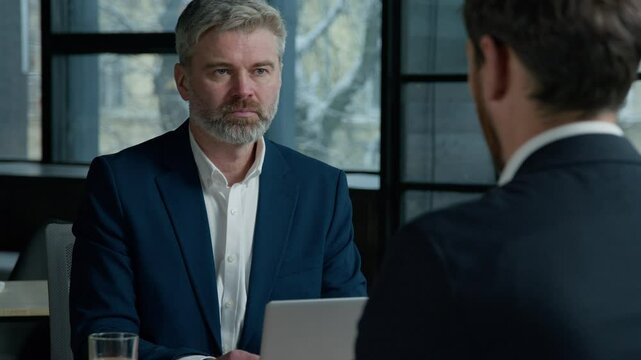 Serious Caucasian man consultant businessman consulting client business job interview in office employer hr manager communicate with male employee candidate men businessmen discuss project at meeting