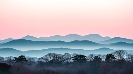 Fototapeta premium Silhouette of mountains at sunrise with a pink and blue sky.