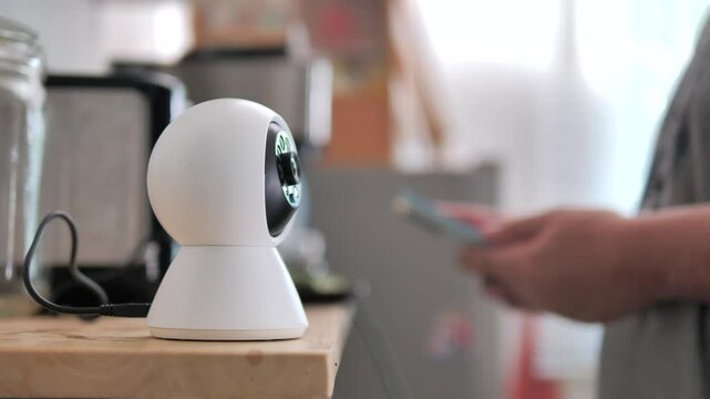 The people use smartphone to control ip camera. Digital surveillance and smart home concept