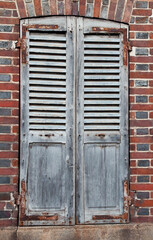 Window with old wooden shutters and rusty fittings