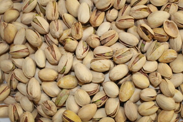 Close-up view of a pile of shelled and unshelled pistachios, showcasing their textures and colors...