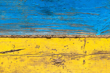 Wooden boards painted blue and yellow. Wooden surface in blue and yellow colors