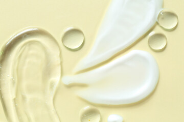 Smears of different cosmetic products on beige background, flat lay