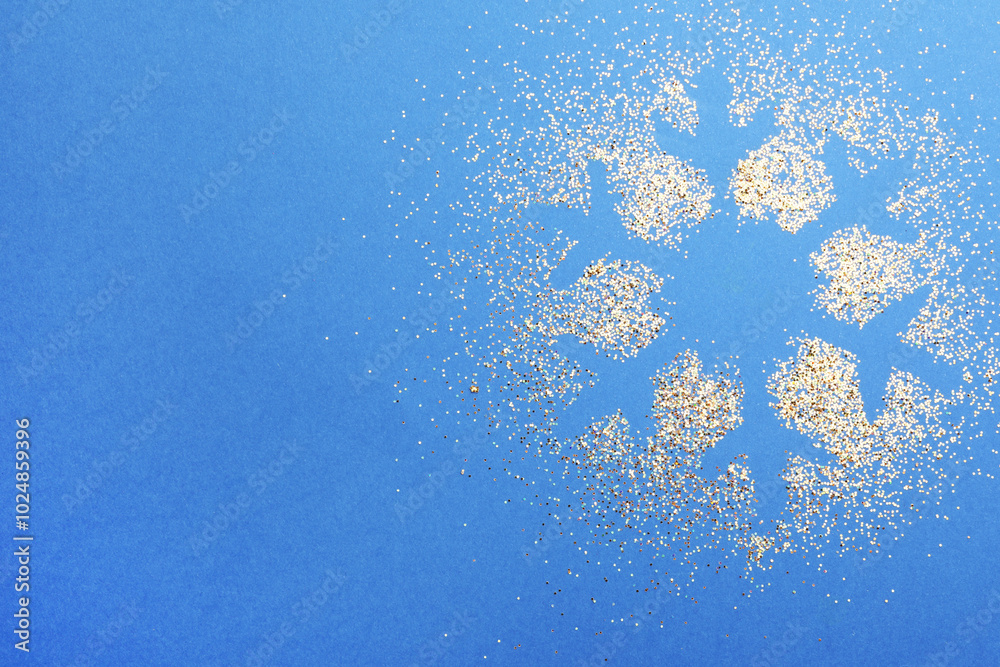 Poster Snowflake made of golden glitter on blue background, top view. Space for text