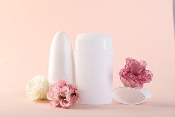 Different deodorants and beautiful eustoma flowers on beige background