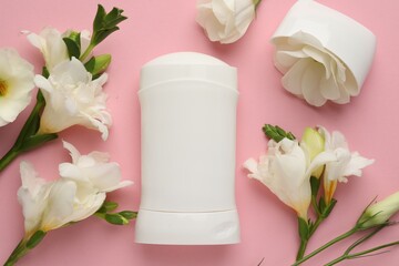 Solid deodorant and beautiful eustoma flowers on pink background, flat lay