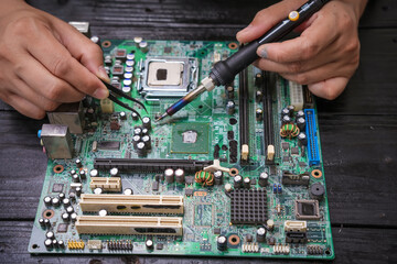 Engineer, a precise computer motherboard repair technician, uses a screwdriver to change parts, focuses on technology maintenance, repairs electronic devices, and supports ideas.