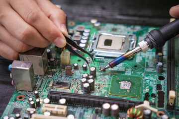Engineer, a precise computer motherboard repair technician, uses a screwdriver to change parts, focuses on technology maintenance, repairs electronic devices, and supports ideas.