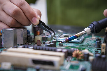 Engineer, a precise computer motherboard repair technician, uses a screwdriver to change parts, focuses on technology maintenance, repairs electronic devices, and supports ideas.