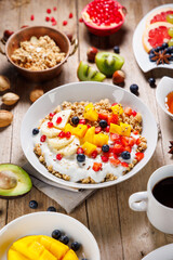 healthy breakfast table with coffee, pancakes, fruits and cereals